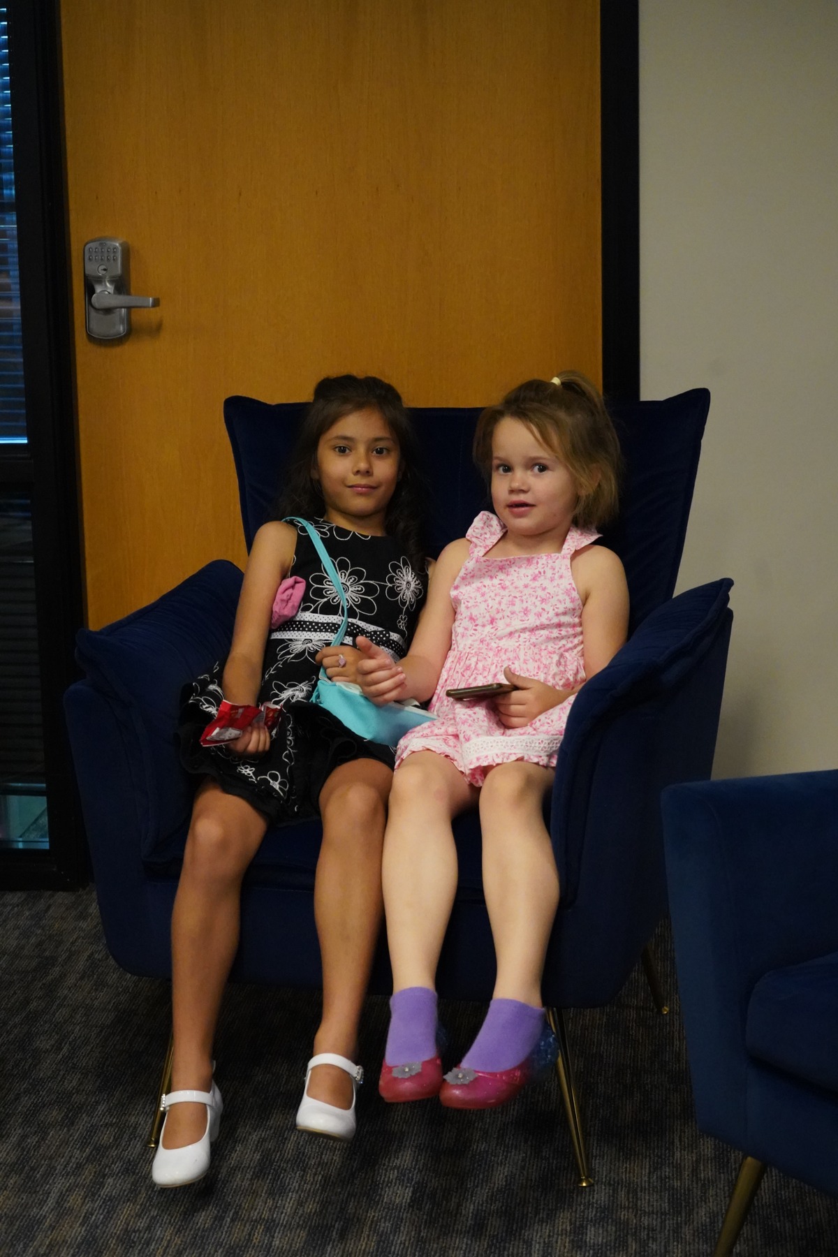 Two children sitting together in a blue chair at Bethesda.