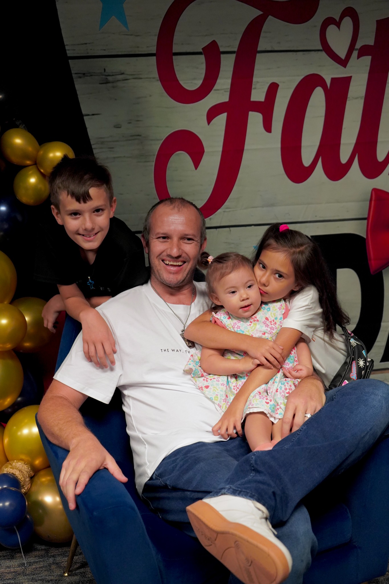 An adult and three children smiling together at Bethesda.