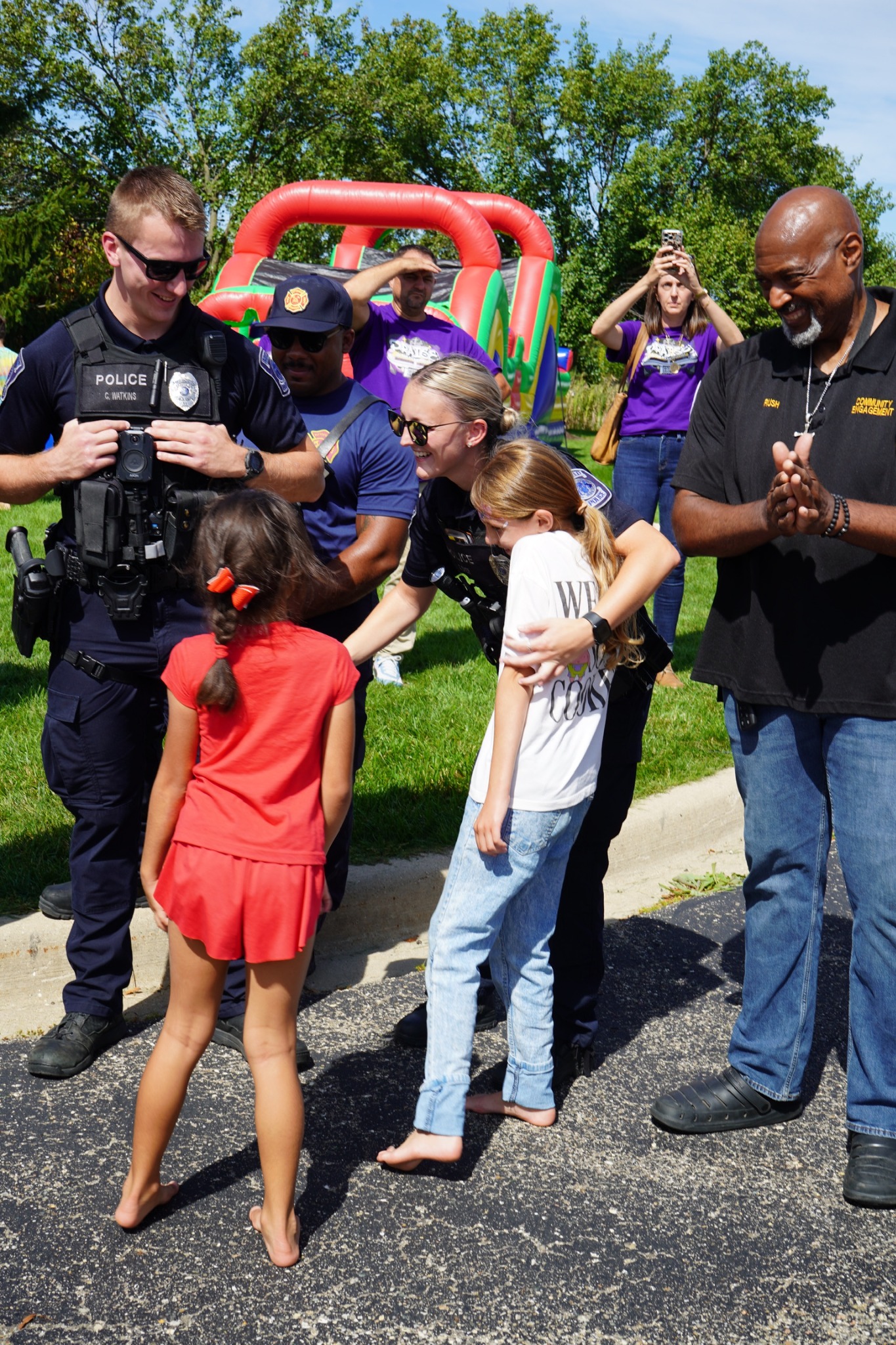 Children and community members meeting police officers at an outdoor church event.